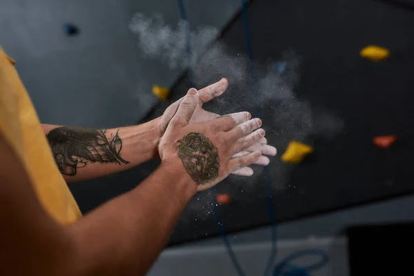 Tiro cortado de homem esportivo aplicando poeira branca de magnésia, giz a mãos antes de escalar a parede no centro de pedregulho. Conceito de vida esportiva e escalada — Fotografia de Stock