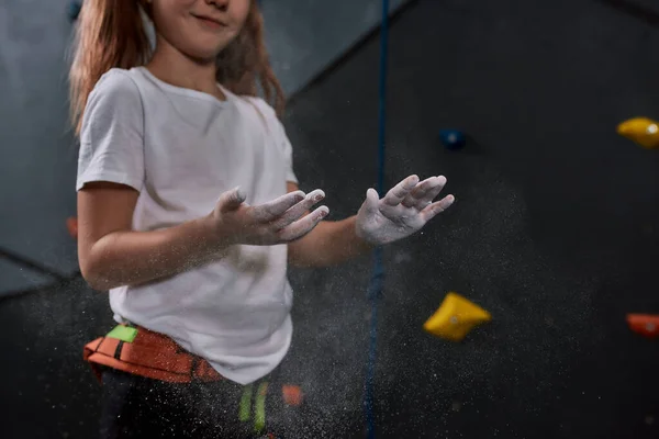 Tiro cortado de criança esportiva, menina aplicando pó branco de magnésia, giz em mãos antes de subir parede no centro de pedregulho. Conceito de vida esportiva e escalada — Fotografia de Stock
