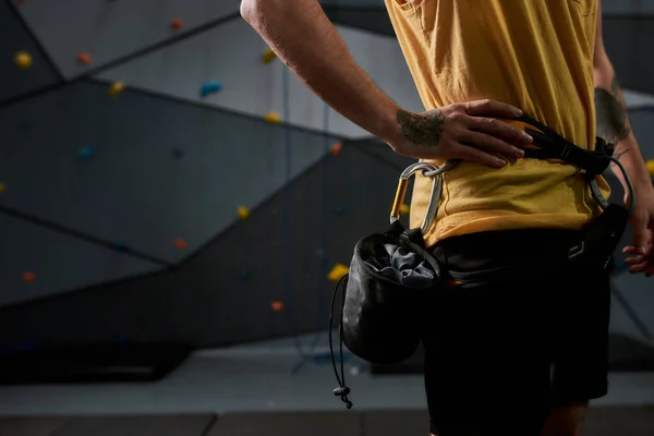 Tiro cortado de homem desportivo, alpinista com um saco de magnésia, giz. Treinamento na parede de escalada artificial. Conceito de vida esportiva e escalada — Fotografia de Stock