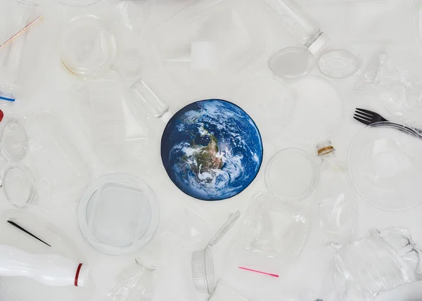 Beyaz zemin üzerinde Dünya 'nın farklı boş plastik kaplar ve kavramsal kağıt modeli ile düz konum — Stok fotoğraf