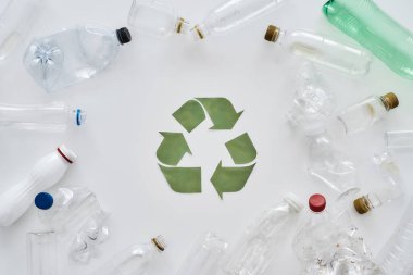 Yemek, uyku, geri dönüşüm. Farklı boş plastik şişelerle düz konum ve beyaz zemin üzerinde kağıttan yapılmış kavramsal geri dönüşüm işareti