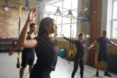 Formda olmaya çalış. Siyah spor giyimli genç bir kadın endüstriyel spor salonunda çalışıyor. Grup eğitim kavramı