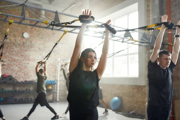 Kompletne ciało. Sportowa młoda kobieta robi ćwiczenia fitness na siłowni przemysłowej. Pompa, koncepcja treningu grupowego — Zdjęcie stockowe