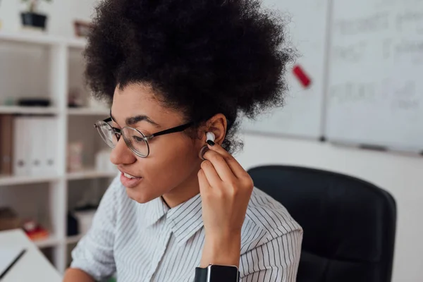Κοντινό πλάνο πορτρέτο της αφροαμερικάνας γυναίκας, γυναίκα δασκάλα προσαρμογή ασύρματων ακουστικών, ενώ δίνει online τάξη μέσω webcam στο σπίτι — Φωτογραφία Αρχείου