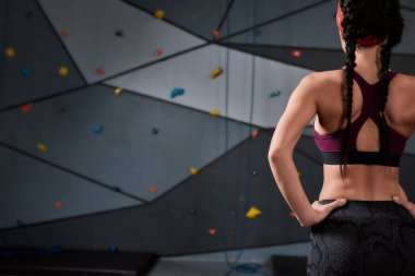 Spor giyim sektöründe aktif genç bir kadın tırmanacak, yapay tırmanma duvarına karşı duracak. Spor hayatı ve kaya tırmanışı kavramı