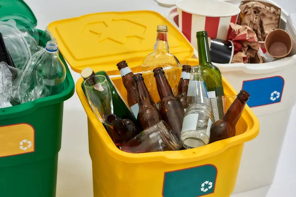 Detailní záběr tří barevných zelených, žlutých a bílých recyklačních popelnic plných odpadků izolovaných na bílém pozadí. Koncept třídění odpadu — Stock fotografie