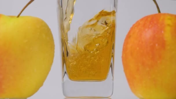 Detox. Zeitlupenaufnahme des Einfüllens von frischem Apfelsaft in Glas und köstlichen Äpfeln vor weißem Hintergrund — Stockvideo