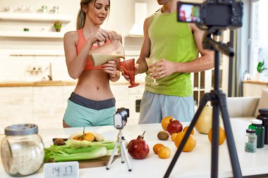 Yaratıcılığını hayata geçirmek. Çift video blogu ya da evdeki sağlıklı beslenme hakkında video blogu kaydediyor. Kadın ve erkek mutfakta dururken smoothie 'yi nasıl hazırlayacaklarını gösteriyorlar.