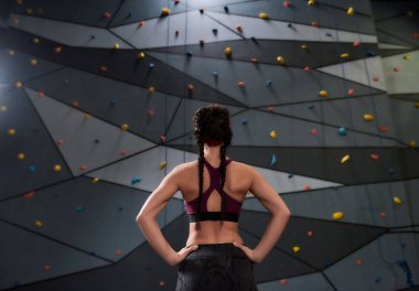 Spor giyim sektöründe aktif genç bir kadın tırmanacak, yapay tırmanma duvarına karşı duracak. Spor hayatı ve kaya tırmanışı kavramı