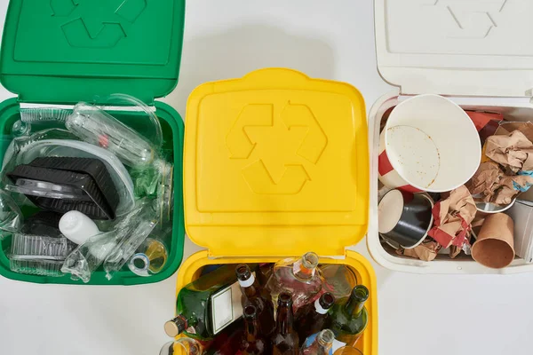 Cropped shot of three colorful green, yellow and white recycle garbage bins full of rubbish isolated on white background. Waste separation concept — Stock Photo, Image