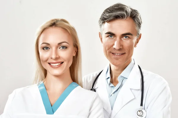 Portrét úspěšného lékařského týmu. Lékaři mužského a ženského pohlaví se dívají do kamery a usmívají se. Pracujeme spolu v nemocnici. Studio shot — Stock fotografie