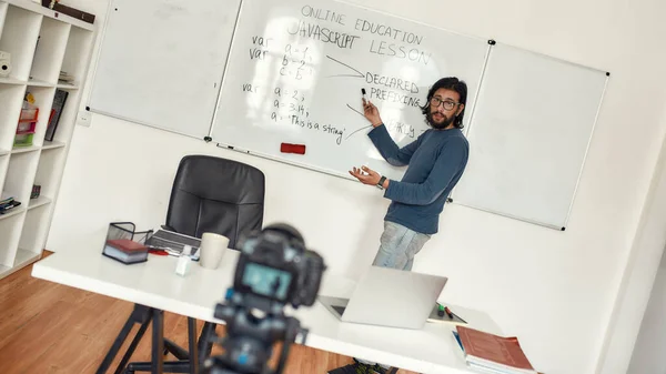 Att lära sig Javaspråk. Professionell manlig lärare som pekar på whiteboard och ger Javascript lektion på nätet, spela in video blogg om professionell digital utrustning — Stockfoto