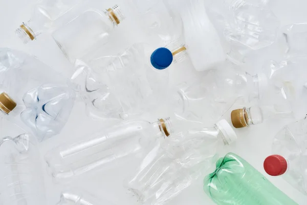 Composición plana con diferentes botellas de plástico vacías sobre fondo blanco — Foto de Stock