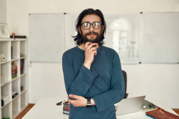 Teaching online. Portrait of young happy caucasian man teacher wearing glasses standing against whiteboard and looking at camera