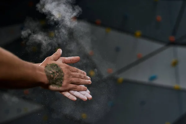 Gros plan des mains de l'homme appliquant de la poussière blanche de magnésie, de la craie sur les mains avant d'escalader le mur au centre du bloc. Concept de vie sportive et d'escalade — Photo