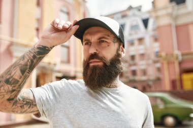 Size hizmet etmeye adanmıştır. Şapkalı vahşi teslimatçı, yana bakıyor, dışarıda duruyor, çalışmaya hazır. Kurye, teslimat hizmeti konsepti