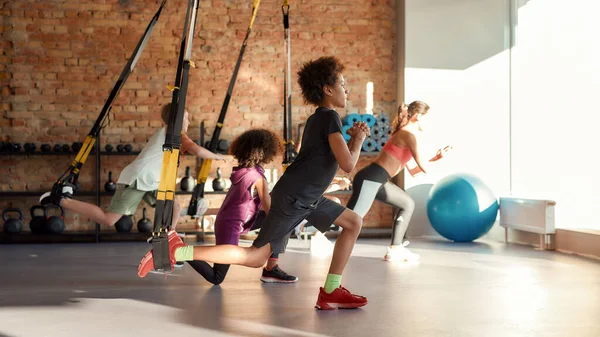 Πορτρέτο της εφηβικής κατάρτισης των παιδιών χρησιμοποιώντας ιμάντες γυμναστικής με γυναικεία γυμναστή. Αθλητισμός, υγιεινός τρόπος ζωής, έννοια της φυσικής αγωγής — Φωτογραφία Αρχείου