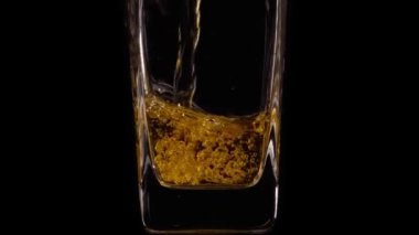 Lezzetli taze elma suyunu şeffaf bir bardağa, siyah arka plana dökerken süper yavaş çekim. Kapatın. Sağlıklı yiyecek, vitamin, meyve.