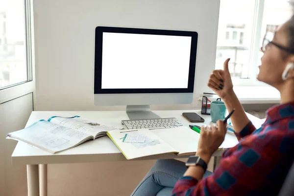 Retrovisore di afro-americana studentessa seduta sul posto di lavoro e che studia online. Concentrarsi su uno schermo del computer vuoto — Foto Stock