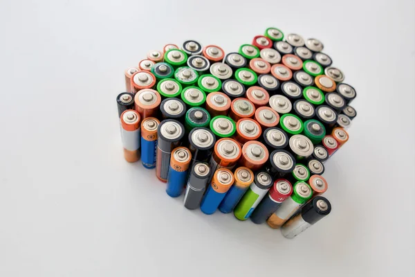 Many alkaline batteries on white background. Concept of recycling waste and environmental pollution — Stock Photo, Image