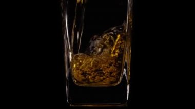 Siyah arka planda şeffaf bir bardağa lezzetli taze elma suyu dökerken yavaş çekim. Kapatın. Sağlıklı yiyecek, vitamin, meyve.