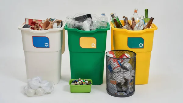 Conjunto de tres coloridos contenedores de basura de reciclaje verde, amarillo y blanco con letrero de reciclaje lleno de basura con otros tipos de contadores aislados sobre fondo blanco. Concepto de separación de residuos — Foto de Stock