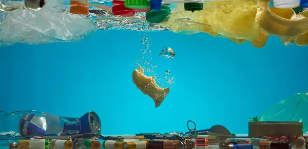 Çöpe atmak yerine yiyecekleri dağıtın. Mavi sudaki plastik poşetleri, pilleri, yiyecek atıklarını ve diğer çöpleri kapatın. Ekolojik felaket ve dünya okyanusu kirliliği — Stok fotoğraf