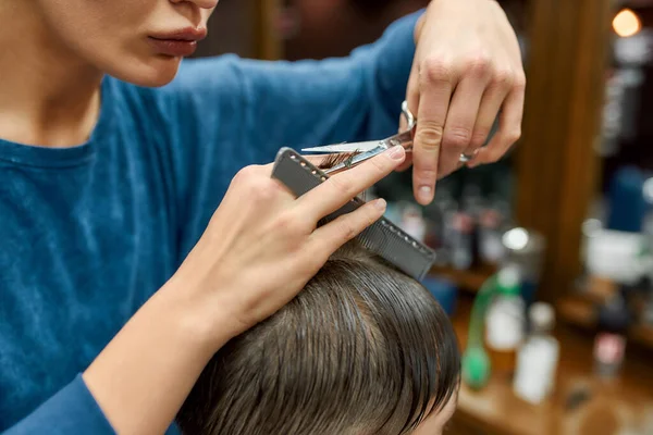 Tiro cortado de mãos cabeleireiro trabalhando com o cliente, fazendo corte de cabelo para um homem que visita barbearia ou salão de beleza. Foco nas mãos — Fotografia de Stock