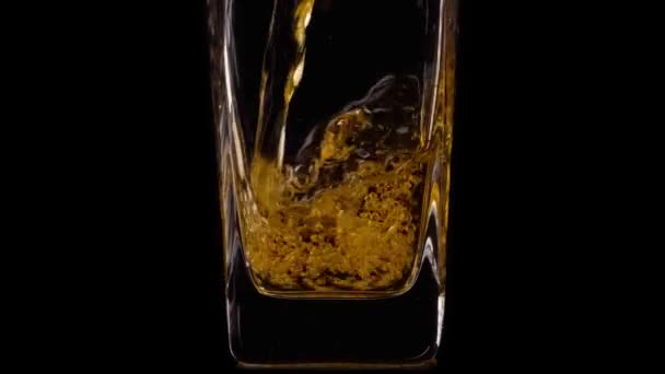 Filme super lento de derramar delicioso suco de maçã fresca em um vidro transparente contra fundo preto. Fecha. Alimentos saudáveis, vitaminas, frutas — Vídeo de Stock
