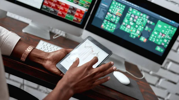 More than just money. Close up shot of hands holding tablet pc. Trader is using touch screen tablet for analyzing stock market chart, while working in the office — Stock Photo, Image