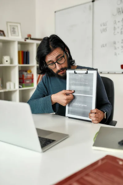 Java language online. Young professional computer programming teacher giving lesson online, explaining java basics while working from home