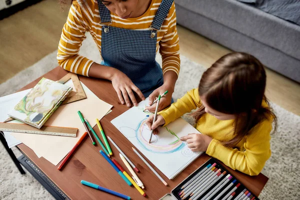 Educación y Cuidado. Niña caucásica pasando tiempo con niñera afroamericana. Están dibujando un ratón juntos —  Fotos de Stock