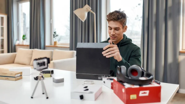 Joven bloguero de tecnología masculina grabación de vídeo blog o vlog desembalaje nuevo PC tableta y otros gadgets en el estudio en casa. Blogging, Trabajo desde el hogar concepto —  Fotos de Stock