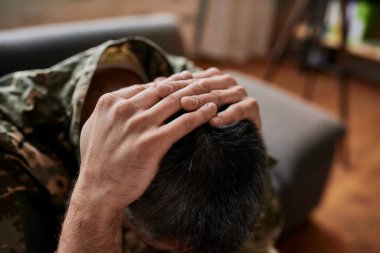 İçinde korku var. Askeri adamın terapi sırasında acı ve depresyon içinde başını tuttuğu yakın plan. Psikolojik travma geçiren bir asker. Travma Sonrası Stres