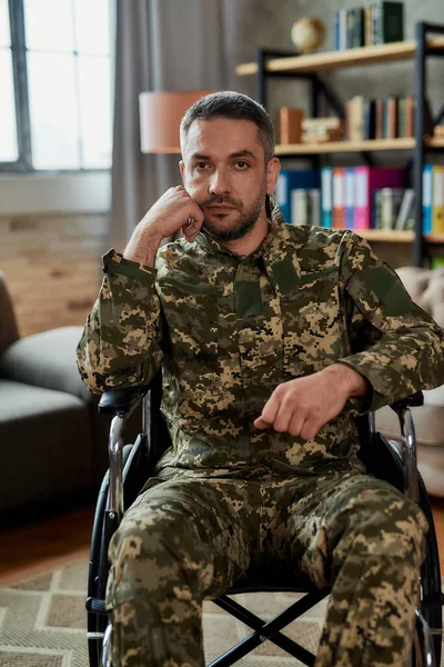 Zet je eroverheen. Bedachtzame militaire man van middelbare leeftijd in een rolstoel die tijdens de therapiesessie naar de camera kijkt. Gehandicapte soldaat die lijdt aan depressie, psychologisch trauma. PTSS-concept — Stockfoto