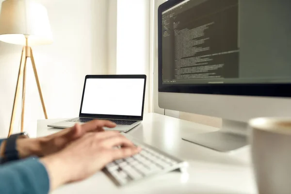 Ritagliato colpo di sviluppatore web maschile scrivere codice sul computer desktop mentre seduto sul suo posto di lavoro e di lavoro da casa — Foto Stock