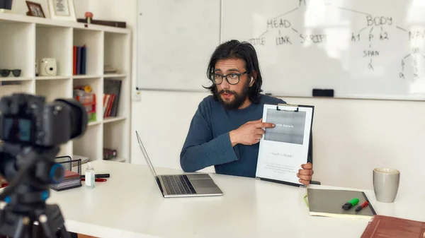 Video blogg om HTML. Ung man bär glasögon lära HTML medan du arbetar online hemifrån. Spela in videohandledning. Fokusera på en lärare — Stockfoto