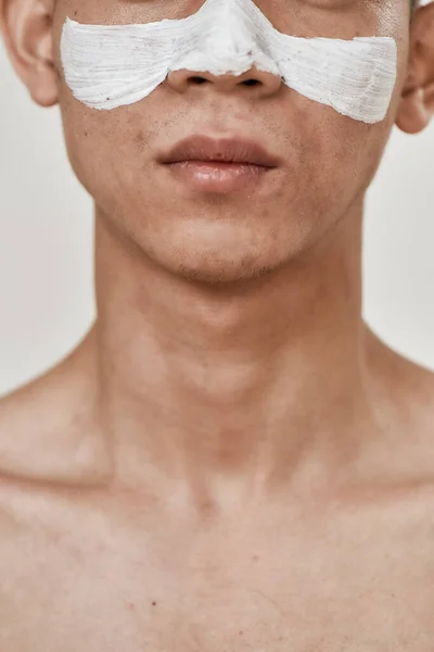 Treatment for your skin. Cropped portrait of young asian man with mask applied on his face isolated over white background. Beauty, skincare routine concept — Stock Photo, Image