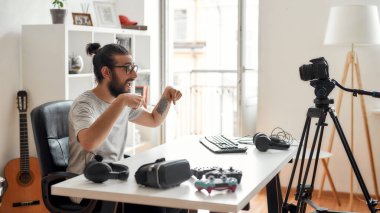 Erkek teknoloji blogcusu aşağıdakileri işaret ediyor, takipçilerden abone olmalarını istiyor, video blogu ya da video bloglarını ev stüdyolarındaki yeni cihazlar hakkında kaydetmelerini istiyor