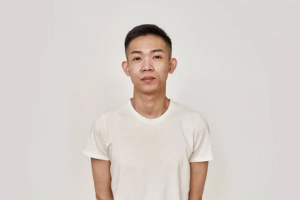 Pele limpa. Retrato de jovem asiático homem com rosto barbeado limpo olhando para câmera isolada sobre fundo branco. Beleza, cuidados com a pele, conceito de saúde — Fotografia de Stock
