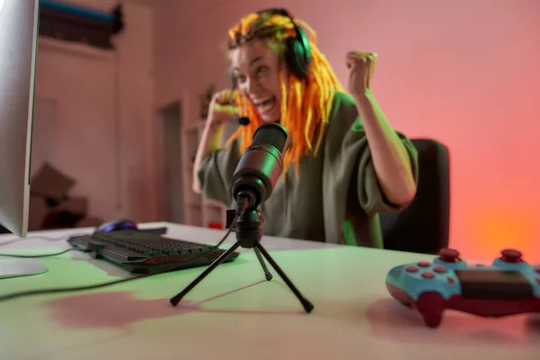 Mujer esport gamer, mujer en auriculares que se ven emocionales, jugando videojuego en línea en el PC durante la grabación, vlog de filmación. Céntrate en el micrófono —  Fotos de Stock