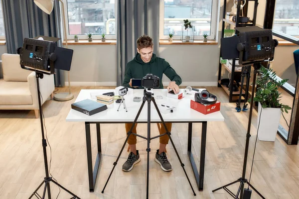 Full längd skott av unga manliga teknik bloggare inspelning video blogg eller vlog om nya smartphone hemma studio. Bloggning, Arbete hemifrån koncept — Stockfoto