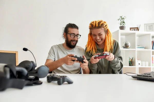 Homem e mulher usando, discutindo joystick controlador de jogo. Jovens blogueiros de tecnologia masculina e feminina gravando vídeo blog ou vlog sobre novos gadgets em casa — Fotografia de Stock