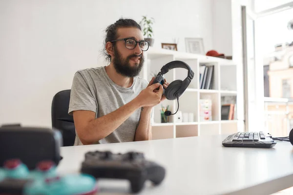 Άντρας blogger τεχνολογίας κρατώντας ακουστικά, αναζητούν δυσαρεστημένοι κατά την εγγραφή βίντεο blog ή vlog για νέα gadgets στο σπίτι στούντιο — Φωτογραφία Αρχείου