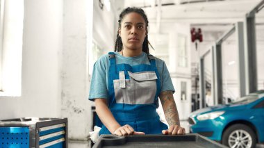 Araban için doktor. Afro-Amerikan kadın, profesyonel kadın tamirci araba tamirhanesinde alet çantası taşıyor. Araba servisi, bakım ve insan konsepti