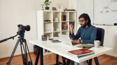 HTML hakkında video dersi kaydediliyor. Profesyonel erkek bilgisayar programlama öğretmeni çevrimiçi ders verirken kameraya bakıyor ve konuşuyor