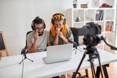 Birkaç blog yazarı, üzgün görünen genç adam ve kadın, dizüstü bilgisayarda bir şey izlerken ağlıyorlar, tepki video blogu veya vlog 'u kaydediyorlar.