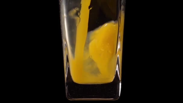 Sabor real. Super toma en cámara lenta de verter jugo de naranja en un vaso transparente sobre fondo negro. De cerca. Bebida saludable, vitaminas, concepto de frutas — Vídeo de stock