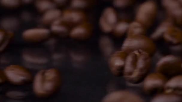 Melhores feijões. Foto em câmera lenta de grãos de café torrados frescos rolando, caindo em mesa de madeira, fundo escuro. Grãos de café fechar vídeo 4K — Vídeo de Stock