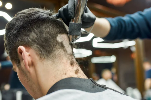 Saç makasıyla çalışan profesyonel berberin yakın plan fotoğrafı, müşteri için moda saç kesimi yapıyor. Berber dükkanını ziyaret eden bir adam. Başının arkasına odaklan. — Stok fotoğraf